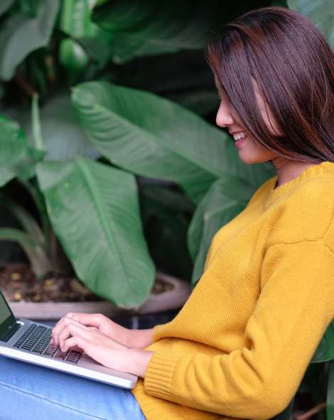 asian woman using laptop surfing interent and sitting outdoor at home garden.digital age technology lifesytyle
