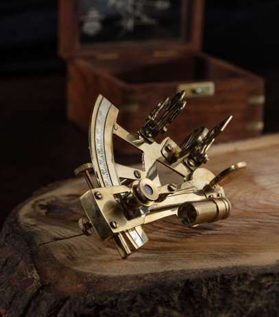 The vintage still life with sextant on wooden table